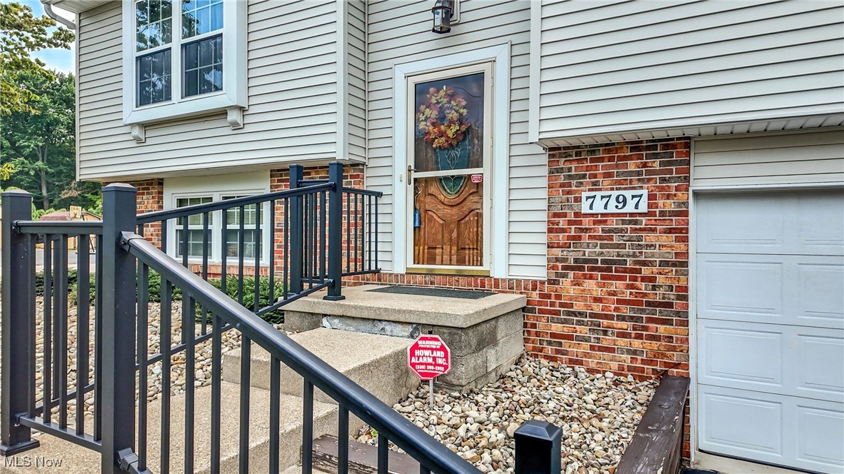 7797 Raglan Drive Northeast Warren, OH 44484 - Photo 7 of 50 Doorway to property featuring a garage and brick siding