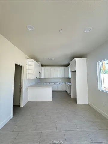 a view of a kitchen with wooden cabinet and a refrigerator