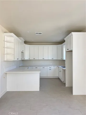 a kitchen with white cabinets and white appliances