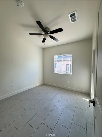 an empty room with windows and fan