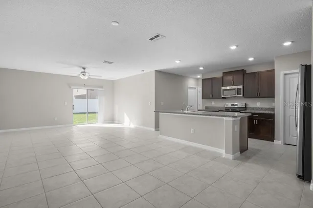 a large kitchen with stainless steel appliances granite countertop a stove a sink and a refrigerator