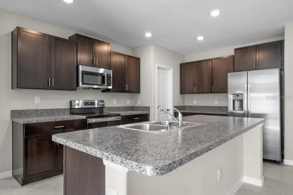 a kitchen with stainless steel appliances granite countertop a sink stove and refrigerator