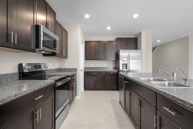 a kitchen with stainless steel appliances granite countertop a sink and stove top oven