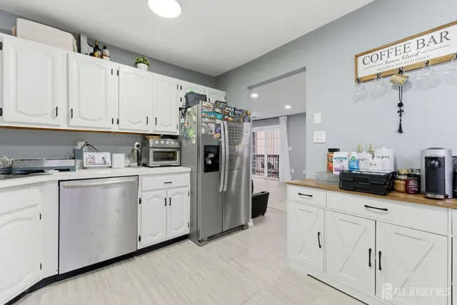 a kitchen with white cabinets and white appliances