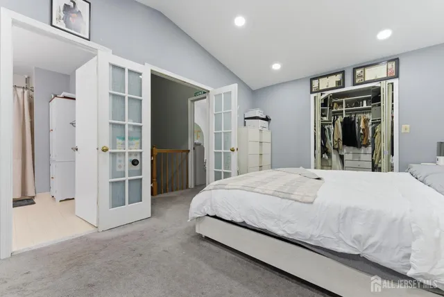 a spacious bedroom with a bed and a large mirror