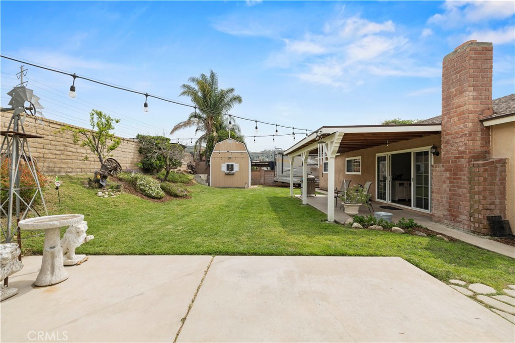 27816 Ridgegrove Drive Saugus, CA 91350 - Photo 57 of 65 a view of a white house with a yard and table and chairs under an umbrella