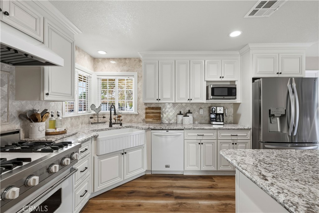 27816 Ridgegrove Drive Saugus, CA 91350 - Photo 8 of 65 a kitchen with stainless steel appliances granite countertop a stove a sink dishwasher a refrigerator and a microwave