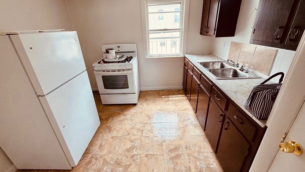 245 County Street, Unit 10 Fall River, MA 02723 - Photo 6 of 9 a kitchen with a refrigerator a stove a sink and a window