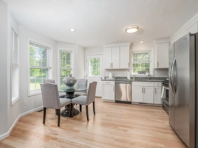 a kitchen with stainless steel appliances granite countertop a white cabinets and wooden floor