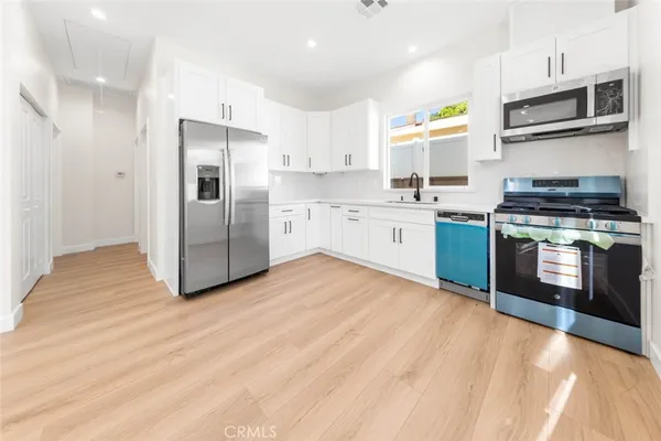 a kitchen with stainless steel appliances granite countertop a stove a sink and a refrigerator