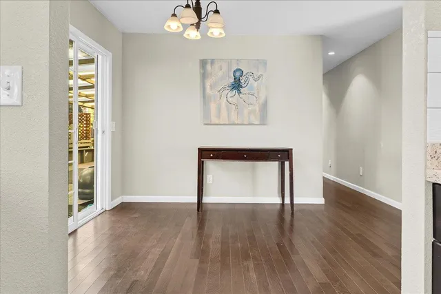 a view of empty room with wooden floor and window
