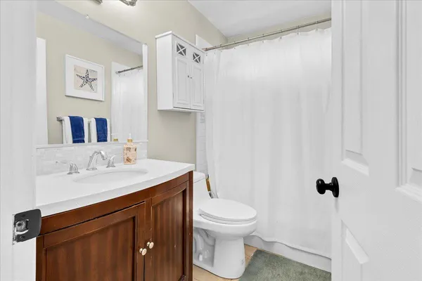 a bathroom with a sink vanity mirror and toilet