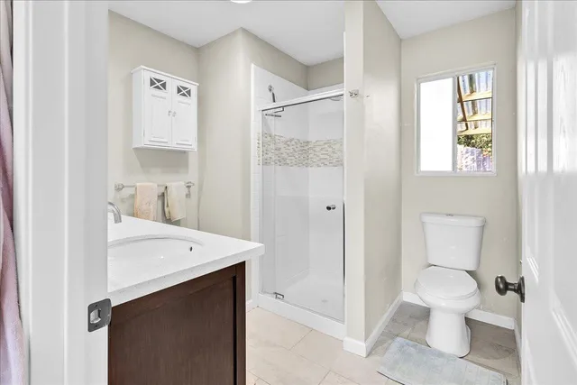 a bathroom with a sink a toilet and shower