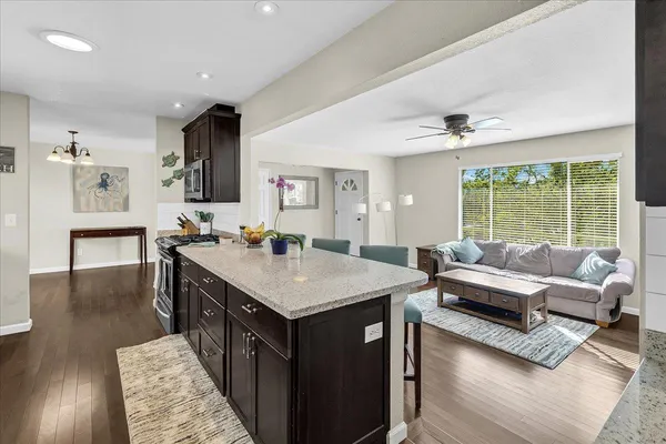 a living room with stainless steel appliances granite countertop furniture and a large window