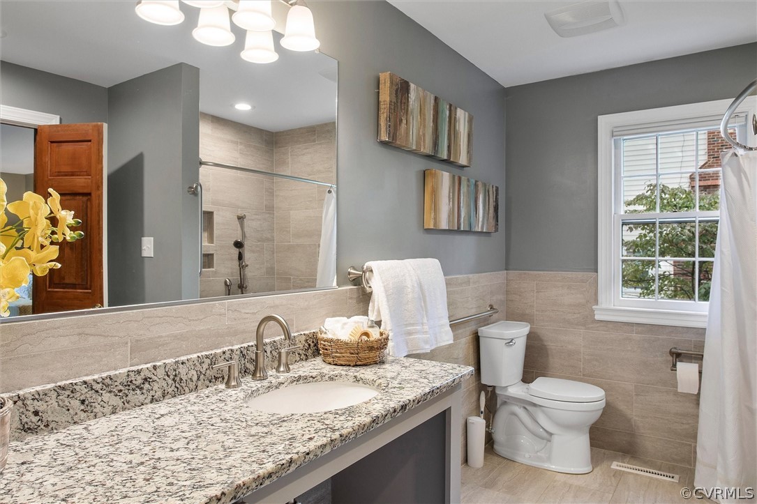 1006 Castle Hollow Road Midlothian, VA 23114 - Photo 27 of 42 a bathroom with a granite countertop sink a toilet and a mirror