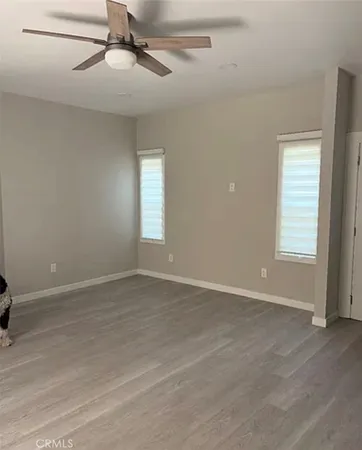 an empty room with windows and fan