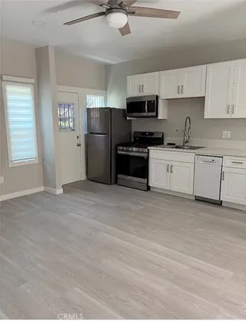 a kitchen with stainless steel appliances granite countertop a stove top oven a refrigerator a sink and dishwasher