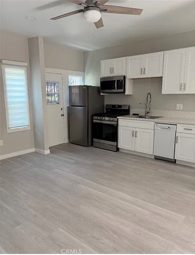1738 East 4th Street Long Beach, CA 90802 - Photo 4 of 7 a kitchen with stainless steel appliances granite countertop a stove top oven a refrigerator a sink and dishwasher