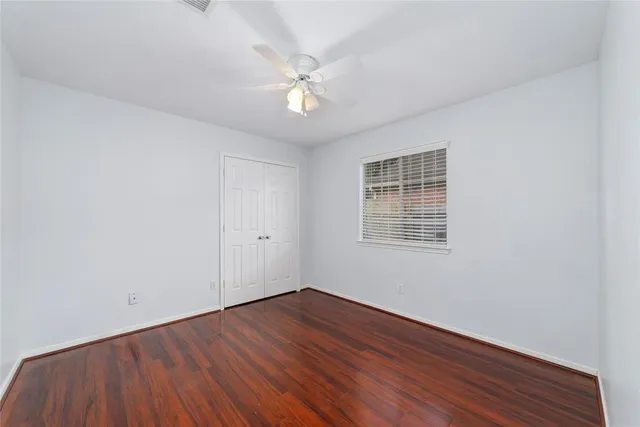 a view of a room with wooden floor and fan