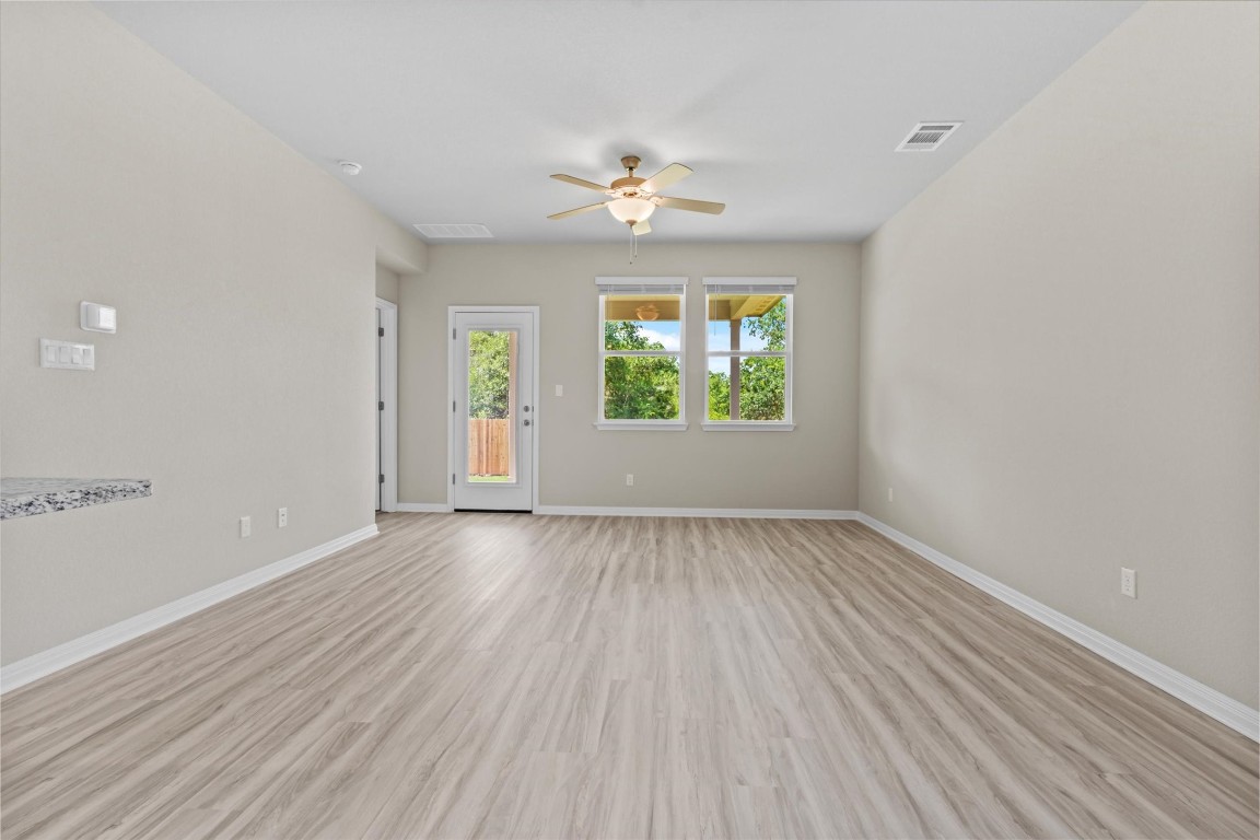 520 View Drive Georgetown, TX 78628 - Photo 7 of 23 an empty room with wooden floor chandelier fan and windows