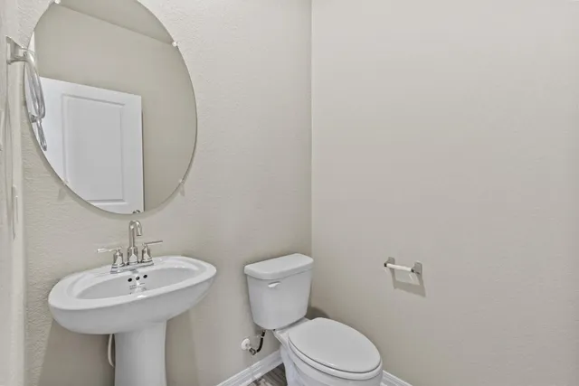 a bathroom with a toilet a sink and mirror