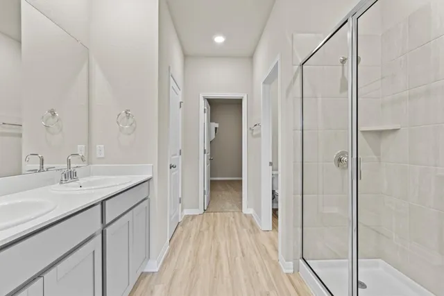 a en suite bathroom with a sink mirror and shower