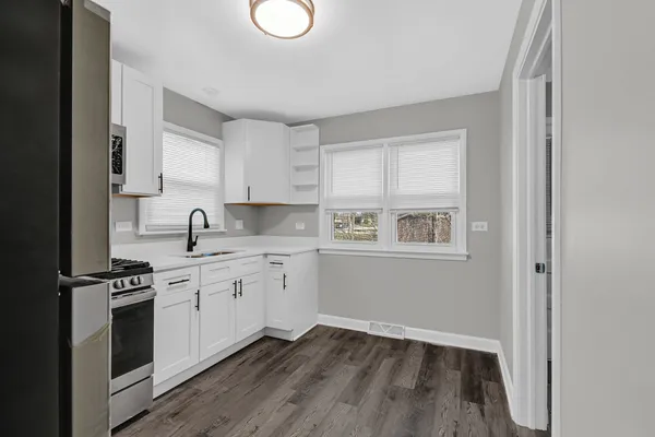 a kitchen with wooden floors and white appliances