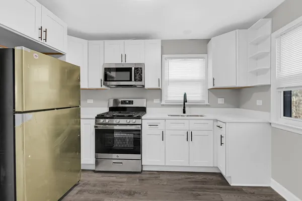 a kitchen with stainless steel appliances a refrigerator stove and microwave