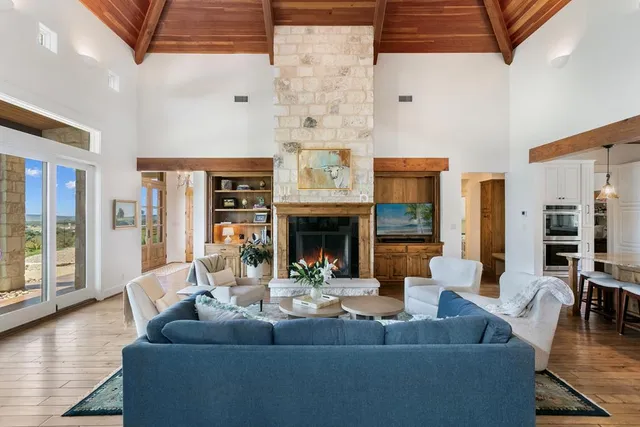 a living room with fireplace furniture and a large window