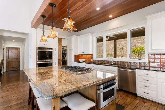 a kitchen with stainless steel appliances granite countertop a stove and a sink