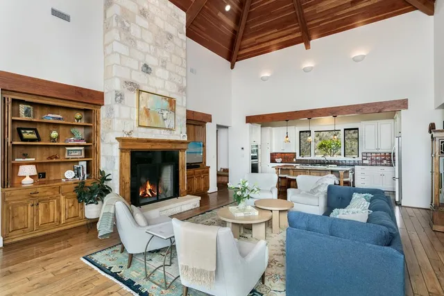 a living room with fireplace furniture and a view of kitchen