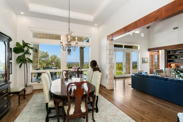 a dining room with furniture potted plants and wooden floor
