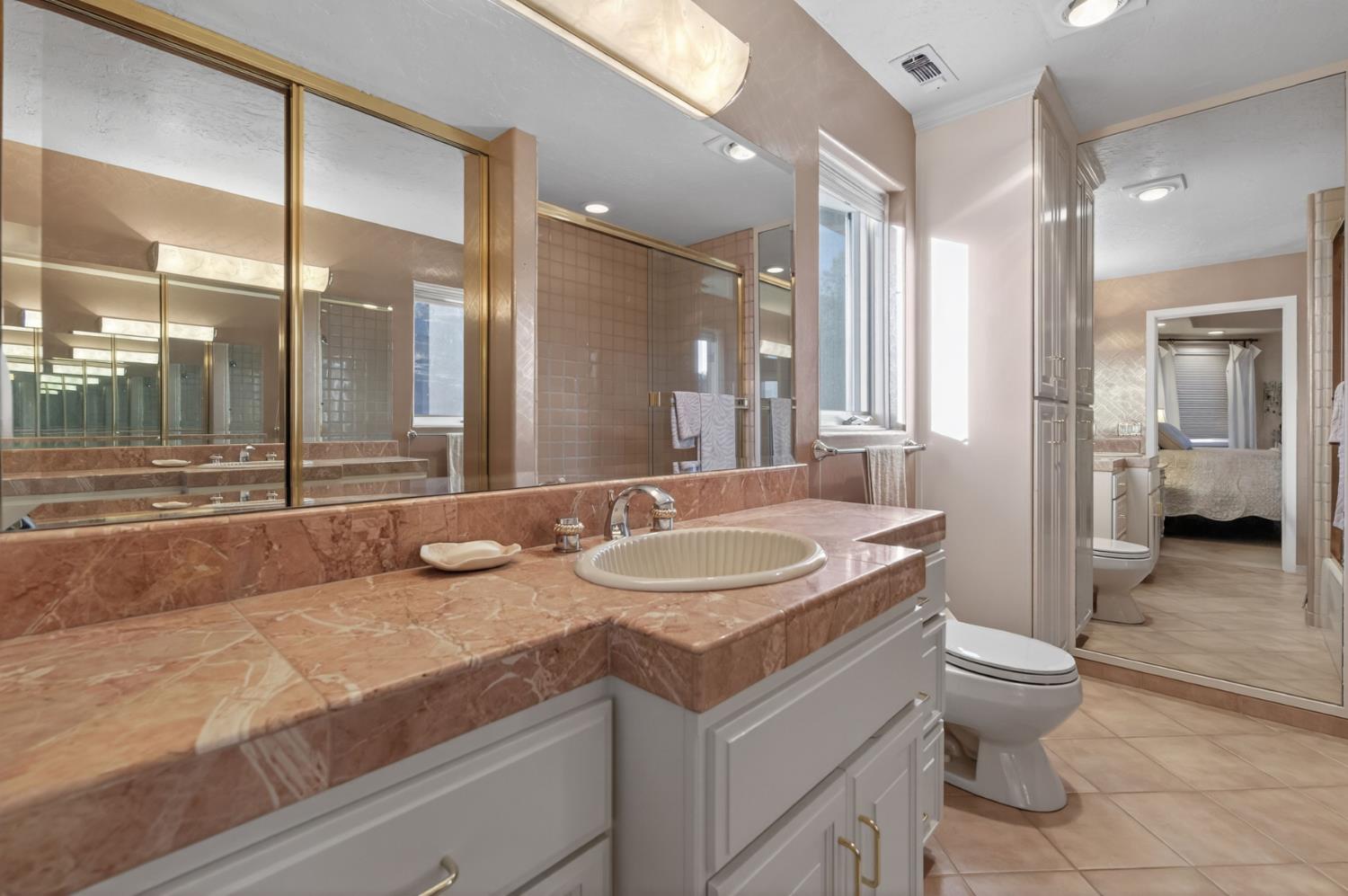 7570 Airola Road Vallecito, CA 95251 - Photo 47 of 90 a bathroom with a granite countertop sink a toilet a mirror and shower