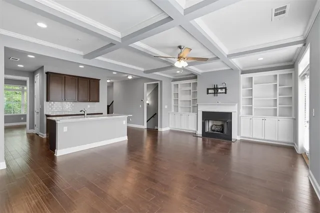 an open kitchen with a refrigerator and a stove top oven