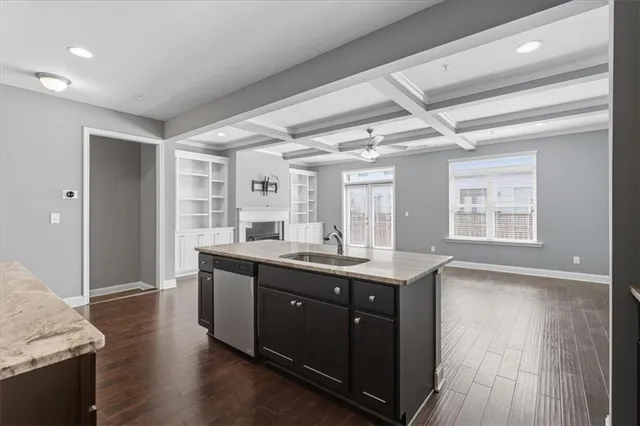 a kitchen with granite countertop a sink and wooden floor