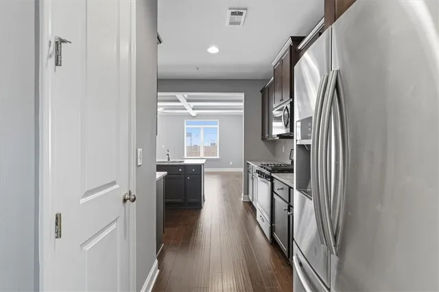 a kitchen with kitchen island wooden floor window and refrigerator