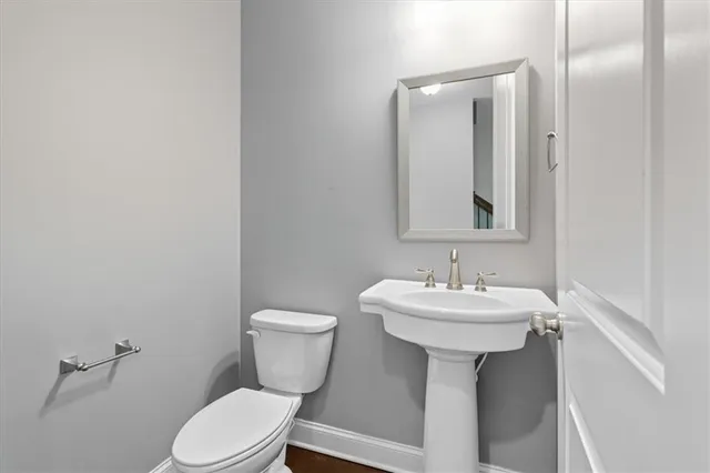 a bathroom with a sink toilet and mirror