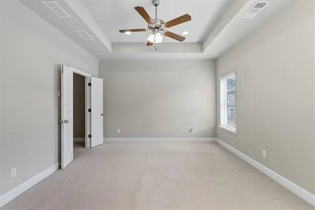 an empty room with closet and windows