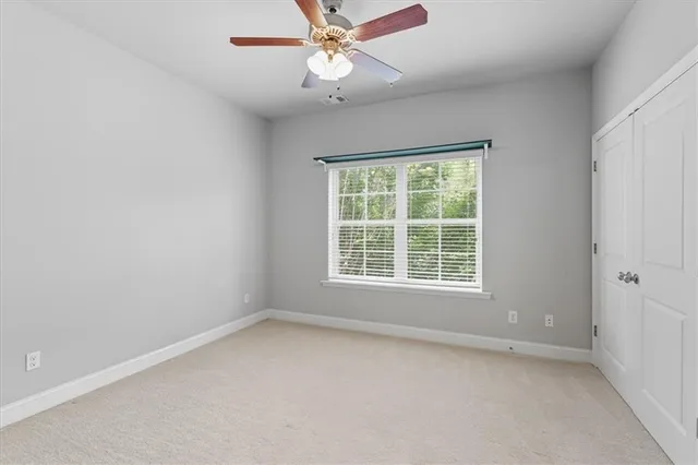 an empty room with a window and a fan
