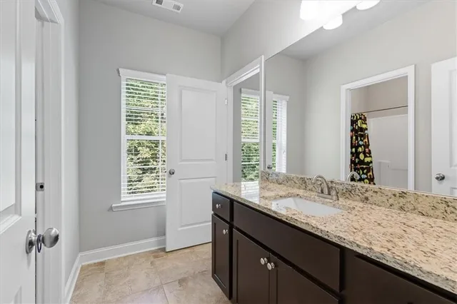 a bathroom with a granite countertop sink and a window