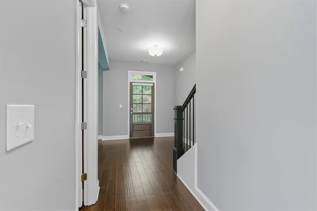 a view of hallway with stairs and wooden floor