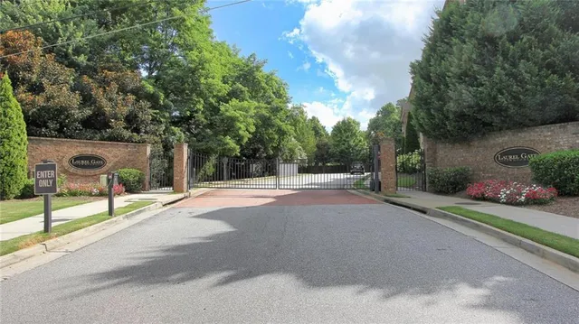 a view of road with house and trees in the background