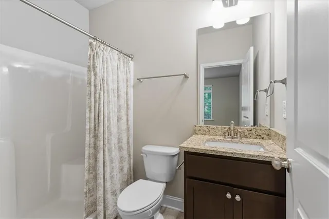 a bathroom with a sink vanity mirror and toilet