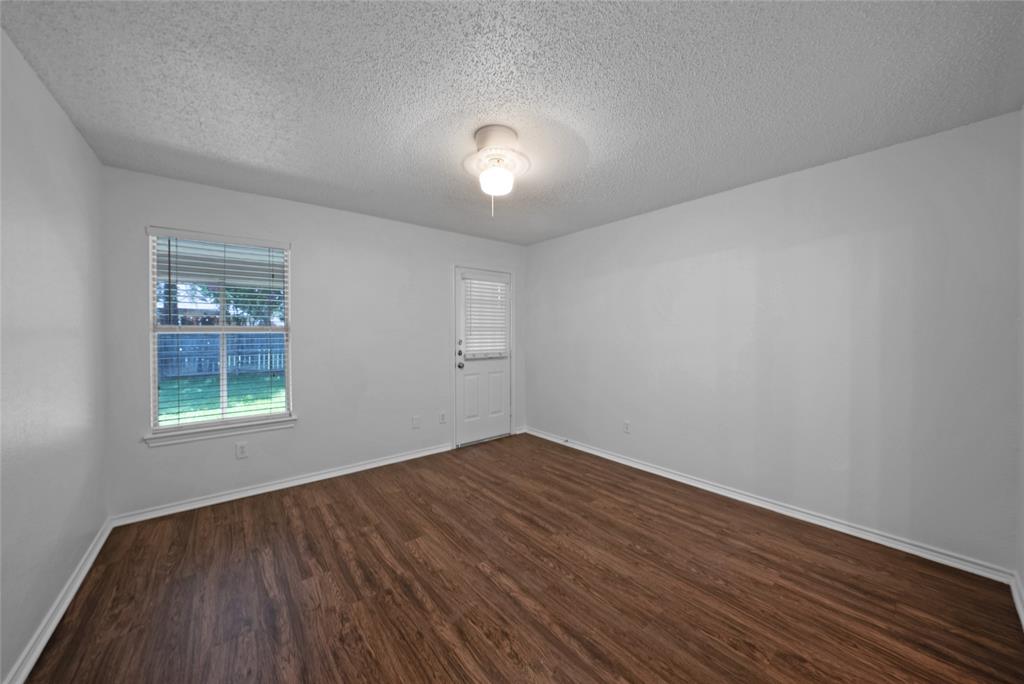 2910 Chisholm Trail Corinth, TX 76210 - Photo 15 of 30 an empty room with wooden floor and windows