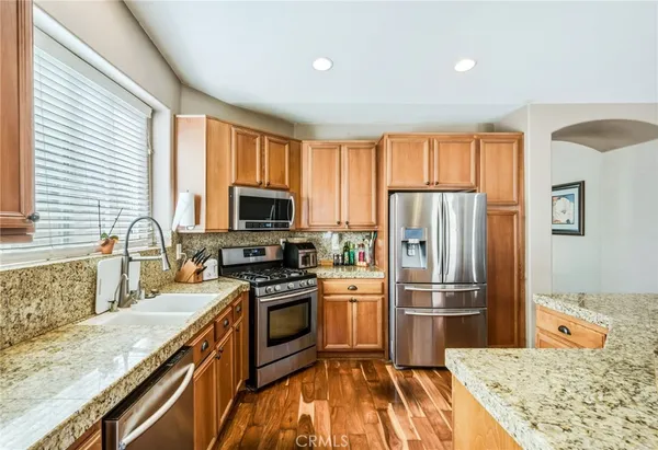 a kitchen with granite countertop a refrigerator stove and sink