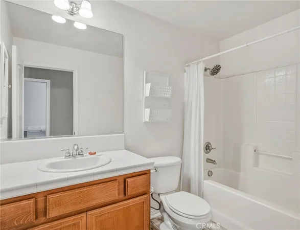 a bathroom with a granite countertop sink toilet a shower and a mirror