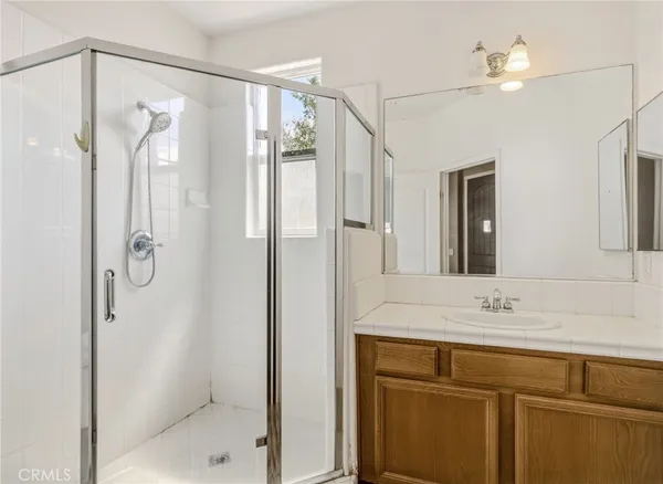 a bathroom with a shower sink and mirror