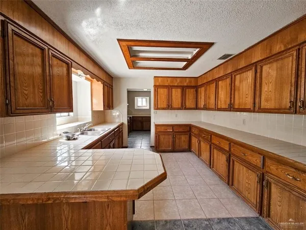 a large kitchen with stainless steel appliances granite countertop a sink and cabinets