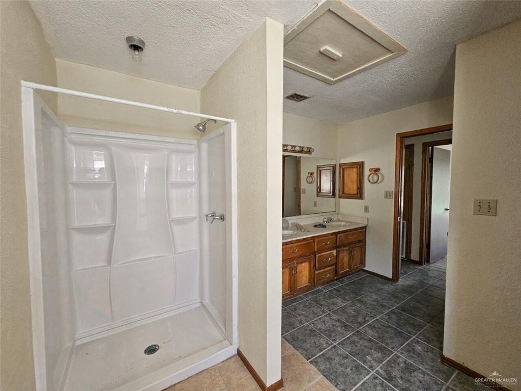 7706 North Jasman Road Edinburg, TX 78542 - Photo 10 of 15 a bathroom with a glass shower door and a sink