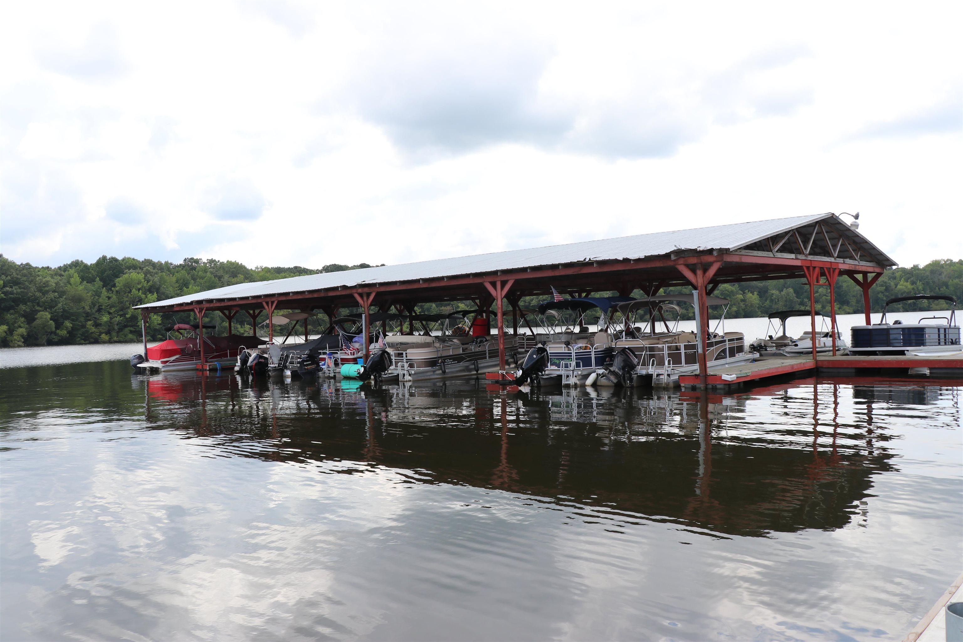 160 Patrick Drive Springville, TN 38256 - Photo 24 of 34 Covered boat dock featuring multiple slips, a metal roof, and a wood frame structure